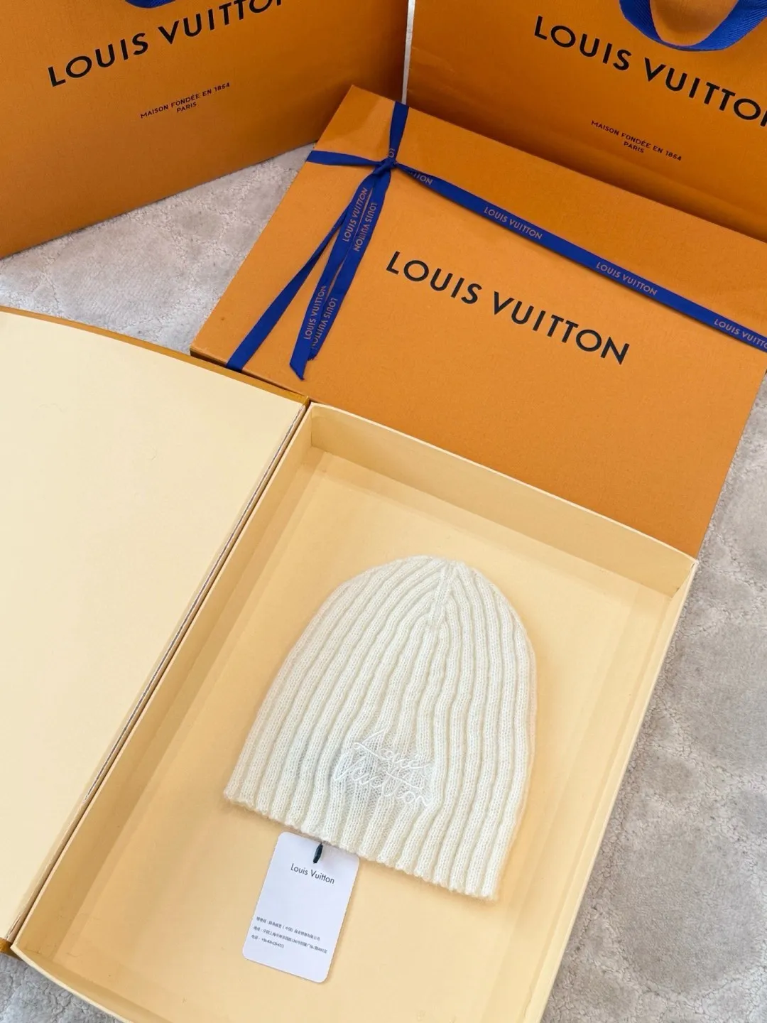 LOUIS VUITTON autumn and winter ski series cold hat ●Original version: purchased and developed for 4200 ●Item number: 1681972-A60 ●Fabric: wool blended fabric ●Technology: knitted ●Color: white/black ●Version: fitted version ●Description: Made of 100% Baby Cashmere (young cashmere), woven with a 28-needle worsted spinning process, the yarn fineness is 14.5 microns, and it feels light and soft. The main body of the hat has a vertical grooved texture, and is elastically wrapped using fixed-spacing stitching techniques to fit a head circumference of 56-58cm. The logo on the front of the hat adopts French satin embroidery technology, and the embroidery thread is made of high-gloss silk thread. The stitch density reaches 90 stitches/square centimeter. The font outline is smooth and not easy to fall off. The cap opening is ribbed with the same material, which has long-lasting elasticity and is not easy to loosen. The finished product is shaped by low-temperature steam to ensure that the hat shape is three-dimensional and crisp. The post-finishing process includes anti-pilling treatment, taking into account both luxurious texture and daily durability. The packaging comes with an exclusive dust bag, continuing the exquisite standards of the brand's high-end accessories. The overall wiring is straight and delicate, the fabric is comfortable and soft, and the color is consistent without color difference. It can be matched with the same style to create a fashionable look and control various occasions. Customized accessories, complete with three standards, same style for men and women!